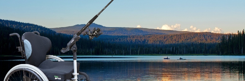 Photo of wheelchair with fishing rod attachment, background is image of a beautiful lake with fishermen in boats.